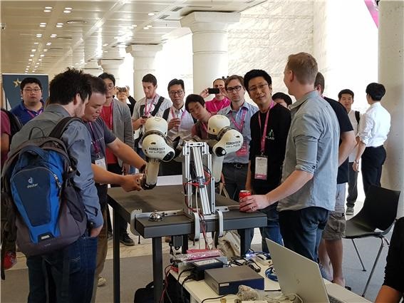 김용재 코리아텍 교수 연구팀이 IROS 2018 국제로봇학회 참가자들에게 로봇팔 ‘앰비덱스’를 시연하고 있다.
