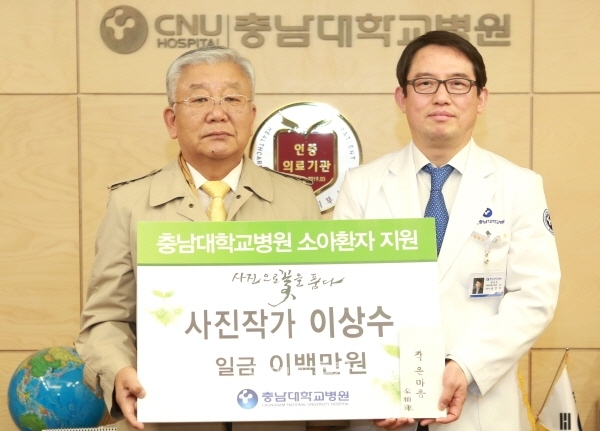 (사진제공=충남대학교병원) 사진작가 이상수(사진 왼쪽) 씨가 소아환자 의료지원을 위해 자신의 사진전 후원금 200만 원을 충남대병원에 기부했다.