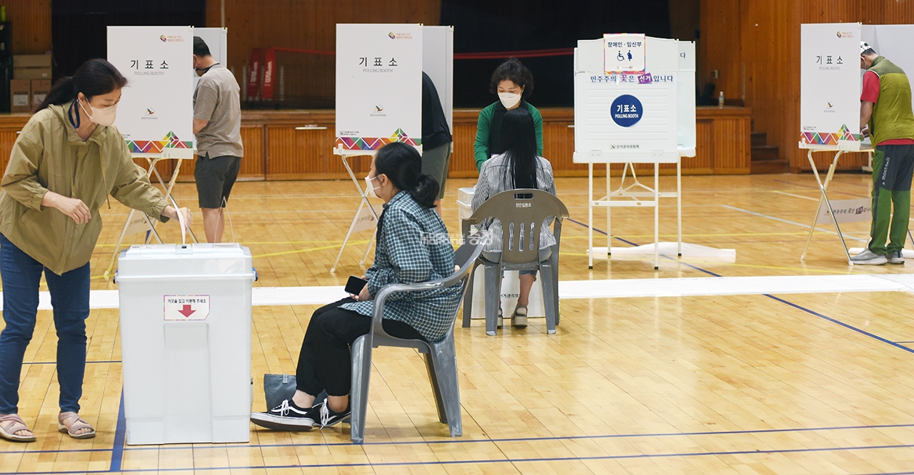 천안시 일봉동 제2투표소인 일봉초에서 유권자들이 투표함에 투표용지를 넣고 있다.
