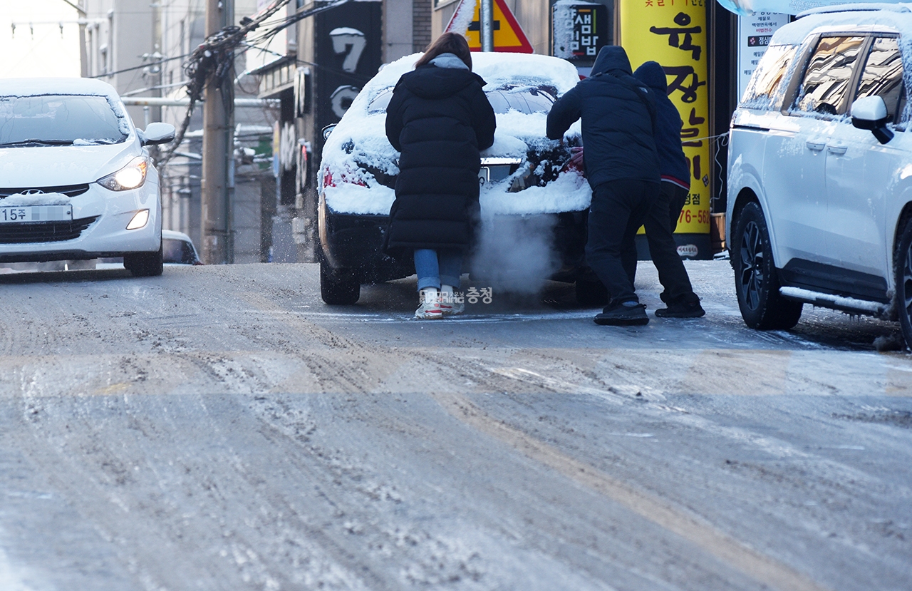 천안시 성정동 한 도로에서 빙판길로 미끄러지는 차량을 시민들이 밀고 있다.(사진=채원상 기자)