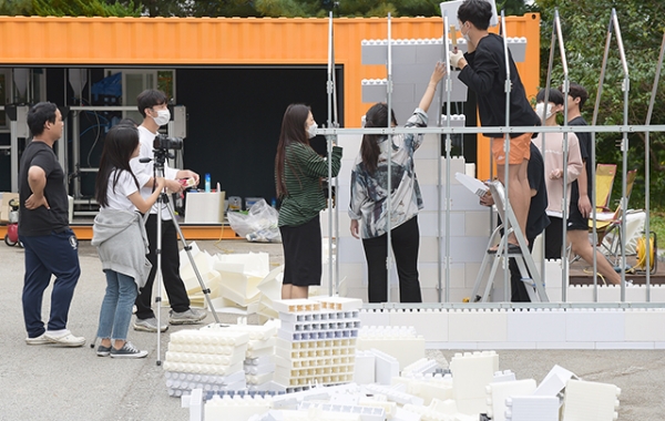 교내 산학협동관 건물밖에 설치한 ‘3D프린팅 파크’ 미니광장 앞에서 건축학과 학생들이 3D로 출력한 소재를 이용해 돔형태의 케빈을 조립, 설치하고 있다.(사진=순천향대 제공)